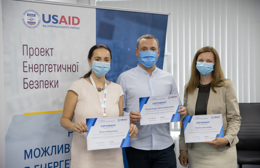 people wearing masks standing with certificates